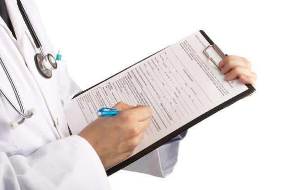 Clipboard and hands of a doctor wearing a labcoat